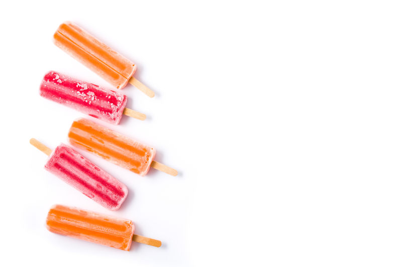 橙色和草莓冰棍白色背景俯视图版权空间