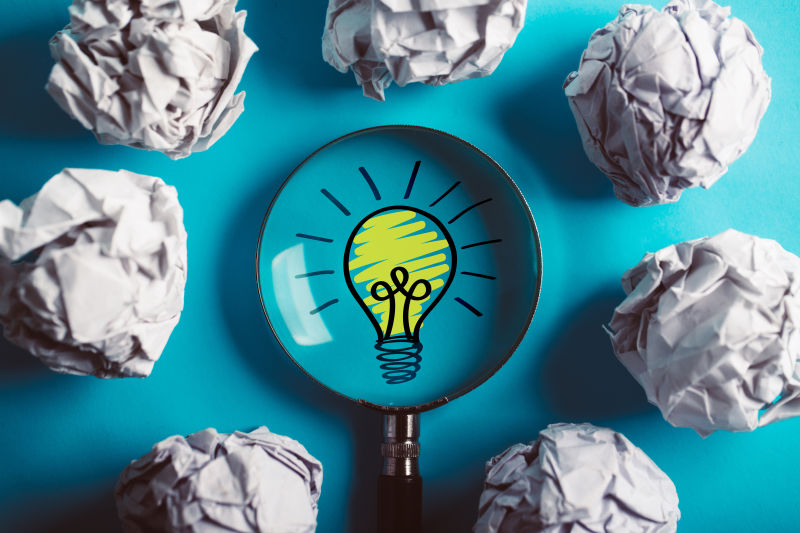 蓝色背景下放大的创意和创新理念