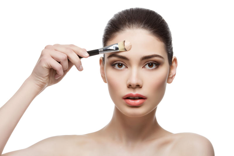 漂亮女孩用刷子粉底