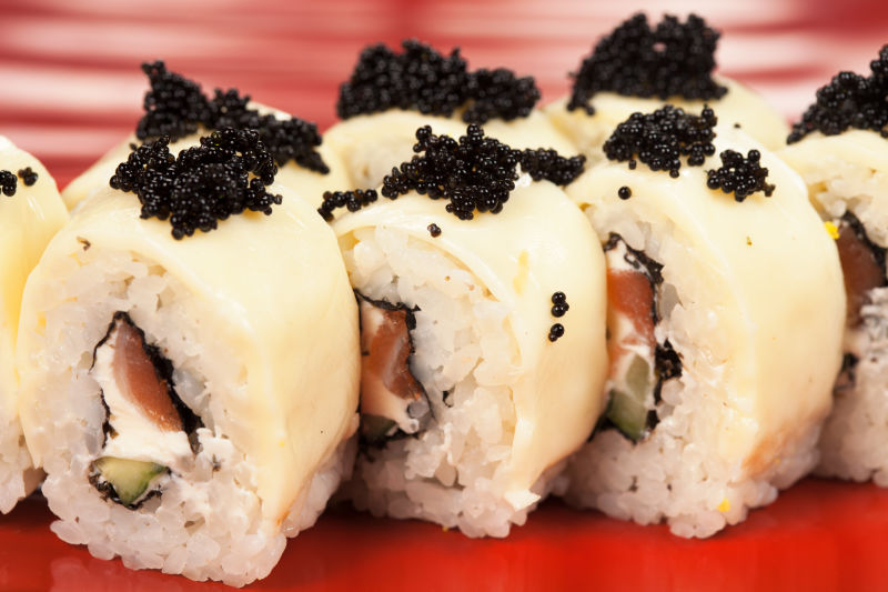 传统的亚洲食物寿司-在白色背景下用木板隔开