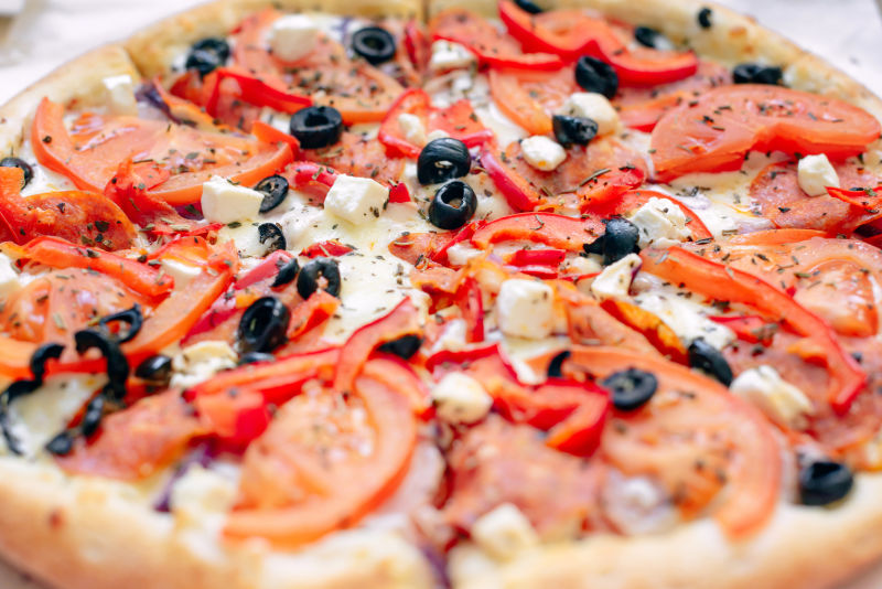 清淡的背景下-放在纸板箱里的美味的希腊披萨-从上面看-为一群朋友点菜