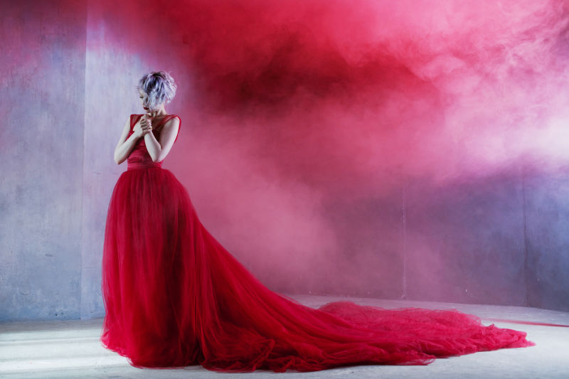 穿着红衣服的年轻漂亮女人的时尚照片纹理背景烟雾
