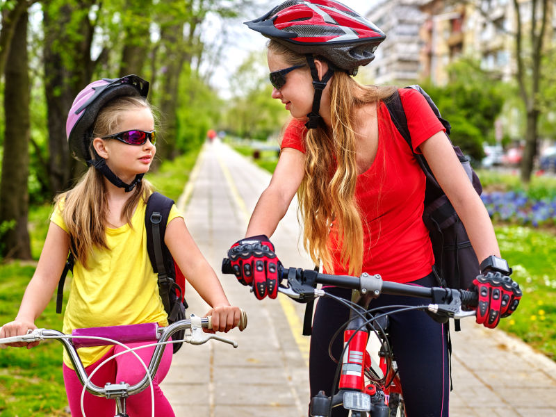 骑自行车的女孩女孩们戴着自行车头盔和自行车用手摇泵女孩给自行车