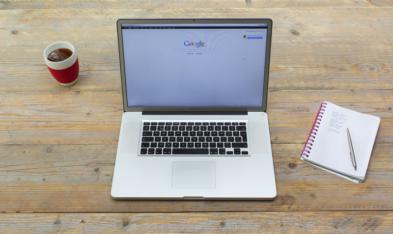 带茶杯或咖啡和白色笔记本的笔记本电脑