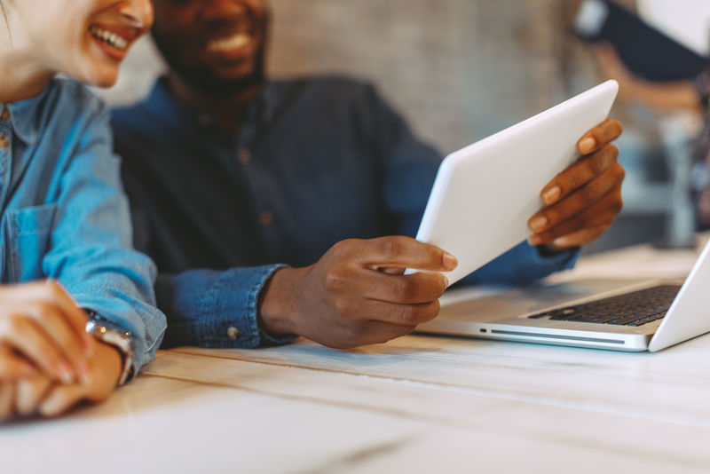 业务合作伙伴讨论平板电脑信息的裁剪图像