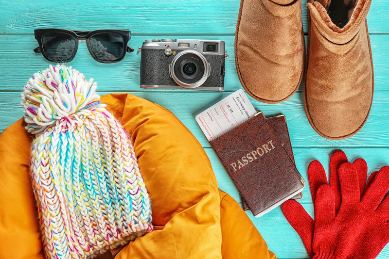 在木制背景上用照相机和文件保暖-寒假概念