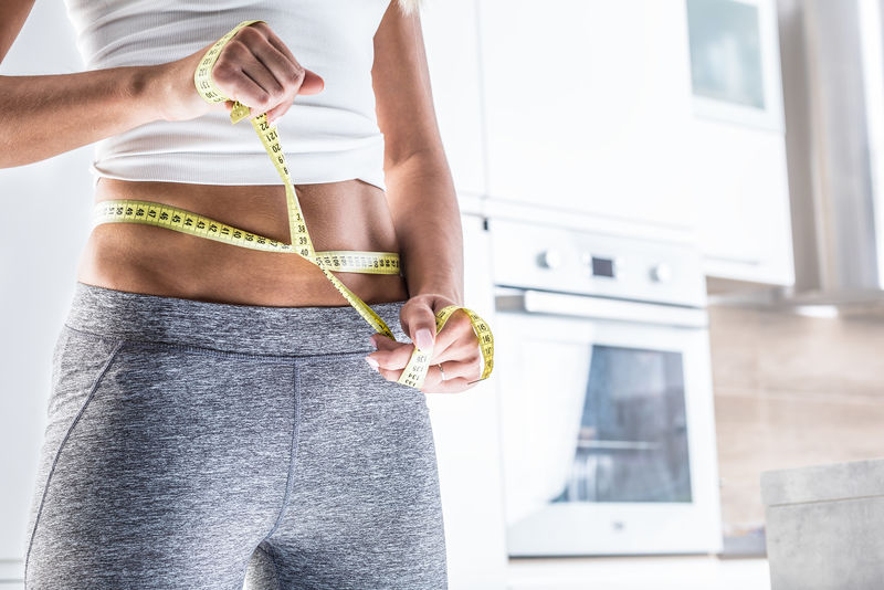 用卷尺测量一个迷人女人的运动形象