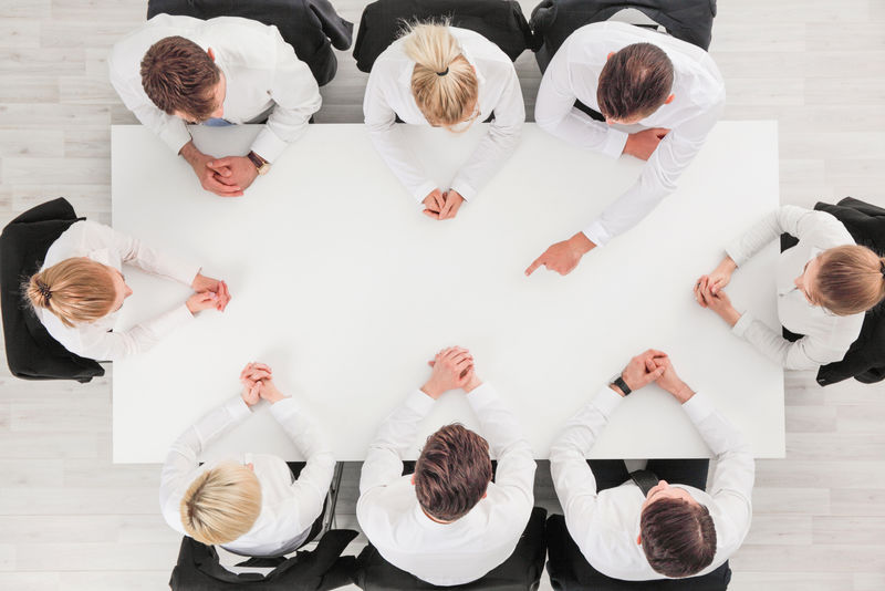 商务人士围坐在空桌子旁-复制文本空间-商务人士指向中间的空白复制空间