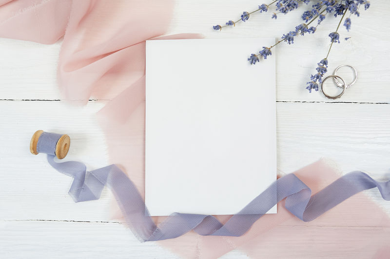 白色空白卡片和带两个结婚戒指的粉色发带