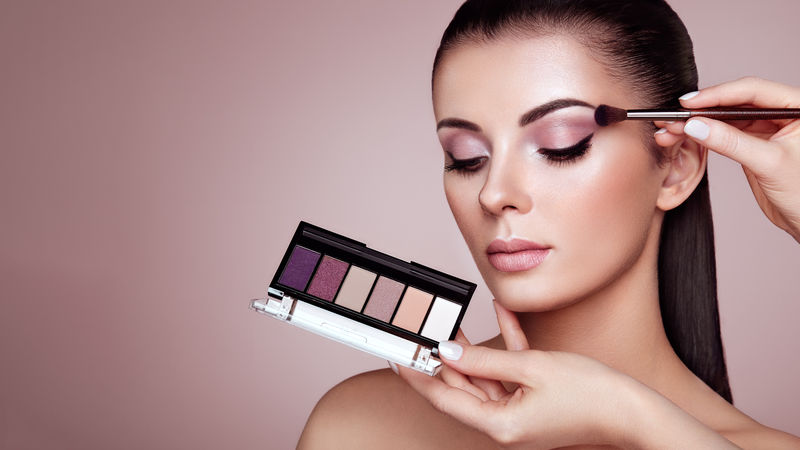 化妆师应用眼影漂亮的女人脸完美的化妆化妆细节皮肤完美的美女指甲和修指甲眼影调色板