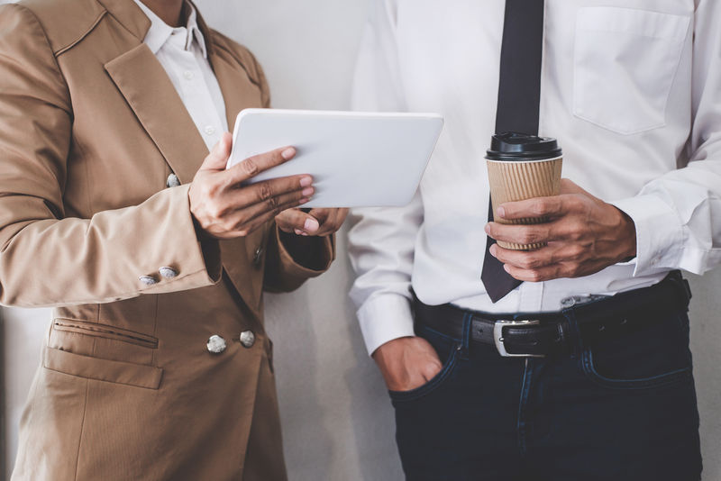 业务团队的同事与新的创业项目计划和讨论信息进行合作和会议-为财务战略与数字平板电脑-他们成功的团队合作的结果