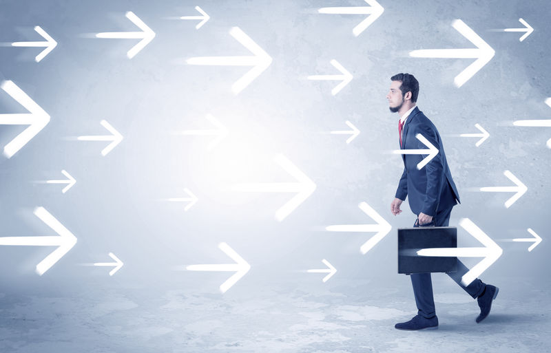 商人背着箭头走着-手里拿着公文包