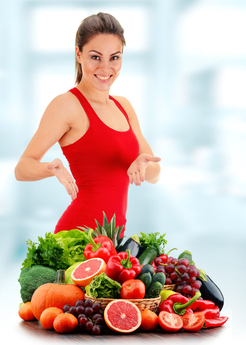 有各种有机蔬菜和水果的年轻女子