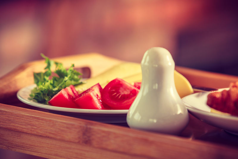 番茄生菜和奶酪放在盐窖旁边的盘子里-早餐食品概念