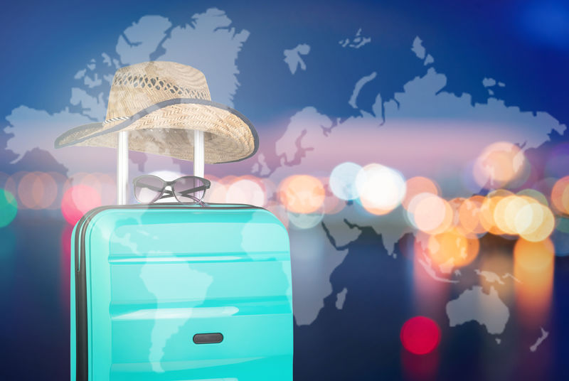 在夜空的背景下-带帽子和太阳镜的塑料手提箱