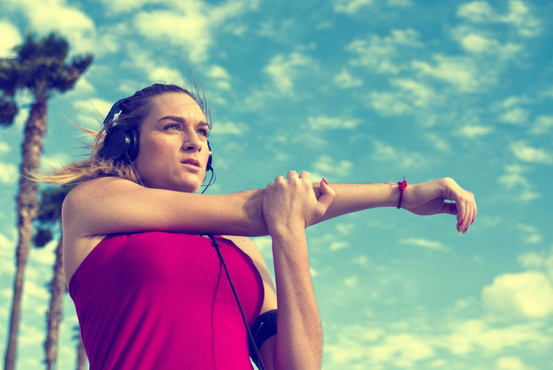 年轻的金发女人一边听音乐一边伸展身体