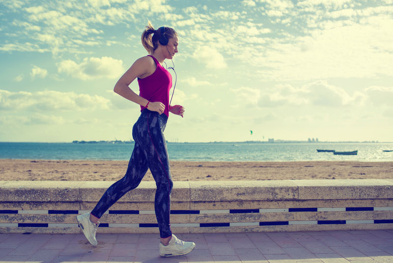 在海滩上奔跑的金发女运动员