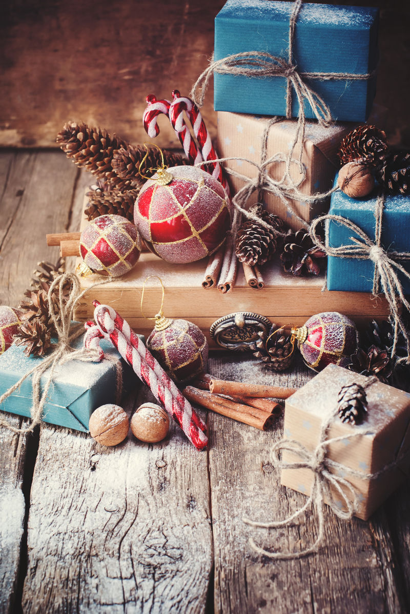 圣诞礼物盒和绳线球松果核桃木制背景的杉树玩具