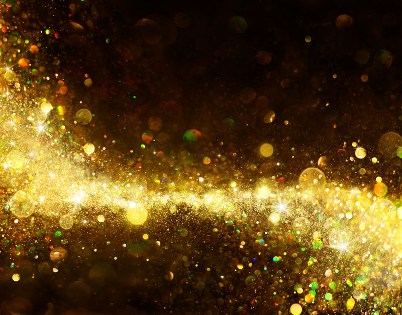 闪亮的金色轨迹在黑色-闪闪发光的灰尘上