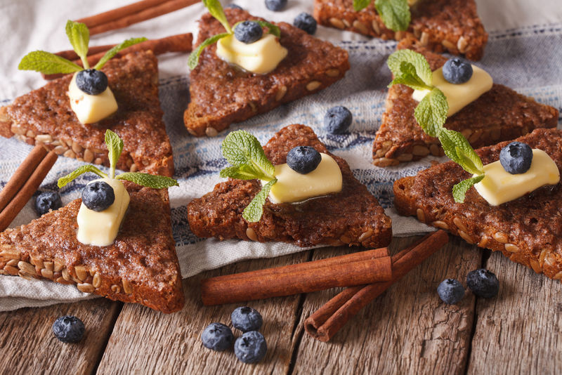 桌上放着黄油和蓝莓的肉桂吐司-水平的