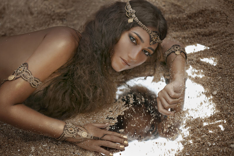 戴着首饰的漂亮女孩镜子上满是沙子