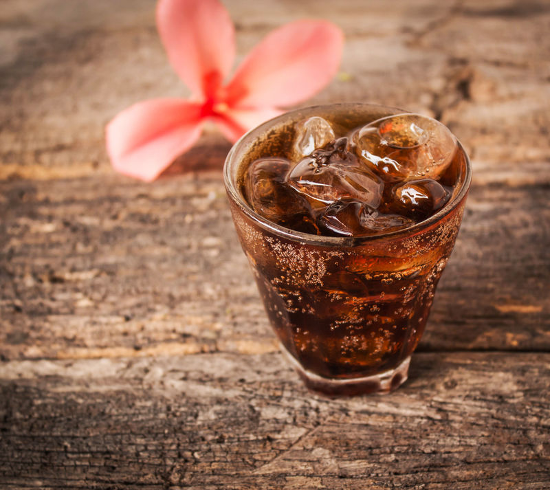 一杯可乐加冰块在木头上