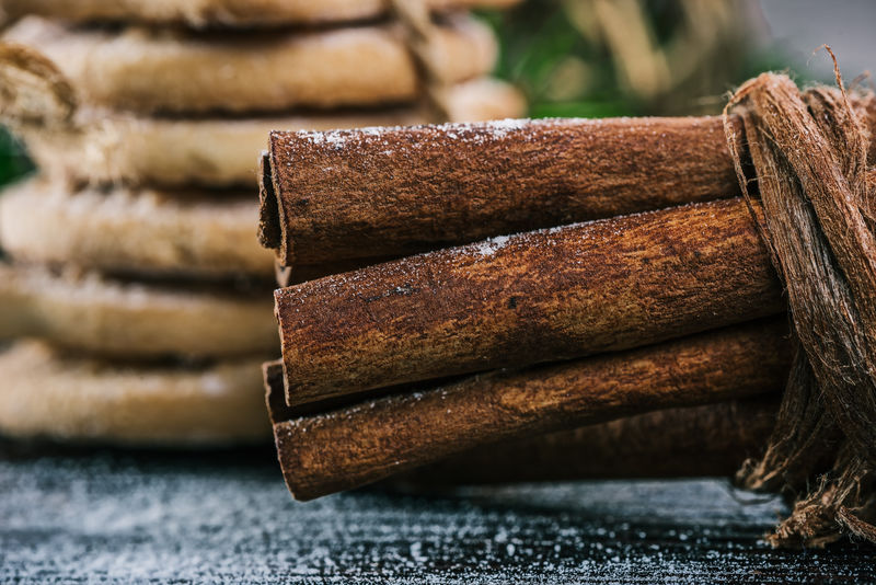 圣诞装饰木桌上的肉桂棒和饼干的特写