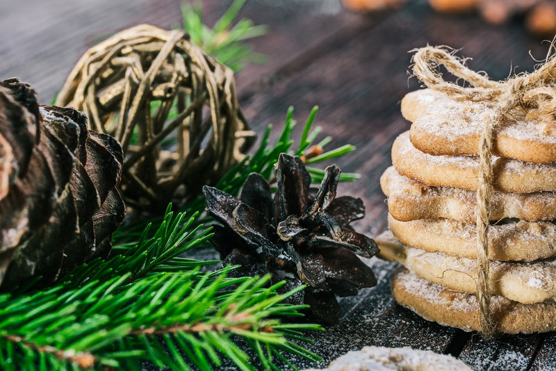 用圣诞装饰品和香料把曲奇饼捆在木桌上的特写镜头选择性聚焦