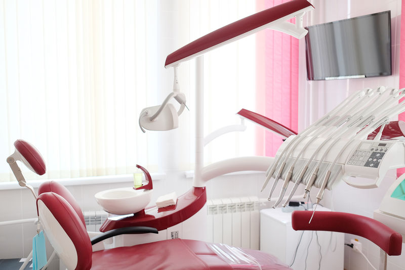 带红色椅子和工具的牙科诊所内部设计