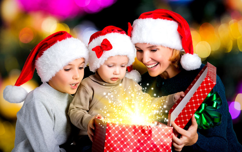 带孩子的母亲打开装有圣诞礼物的盒子