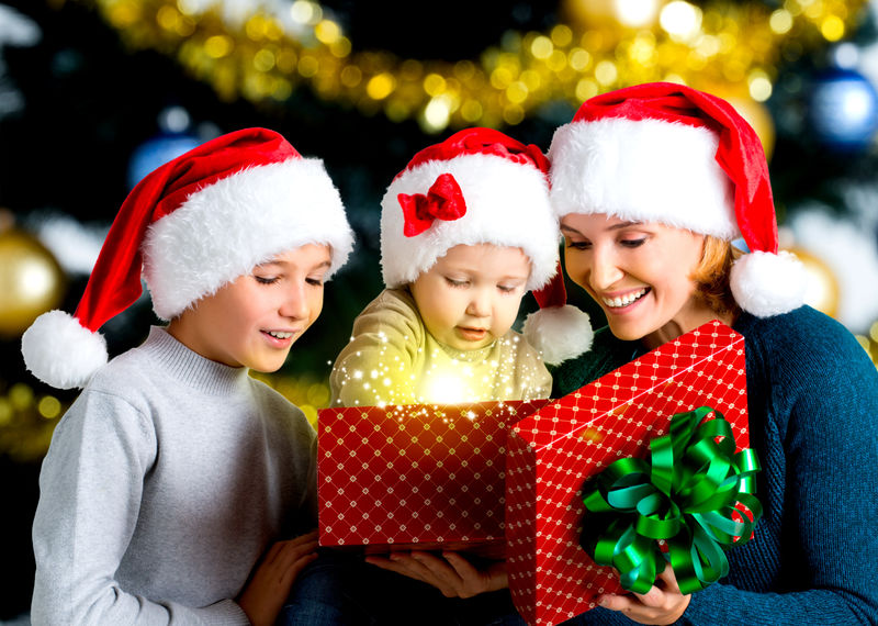 母亲带着孩子在圣诞礼物盒上打开礼物