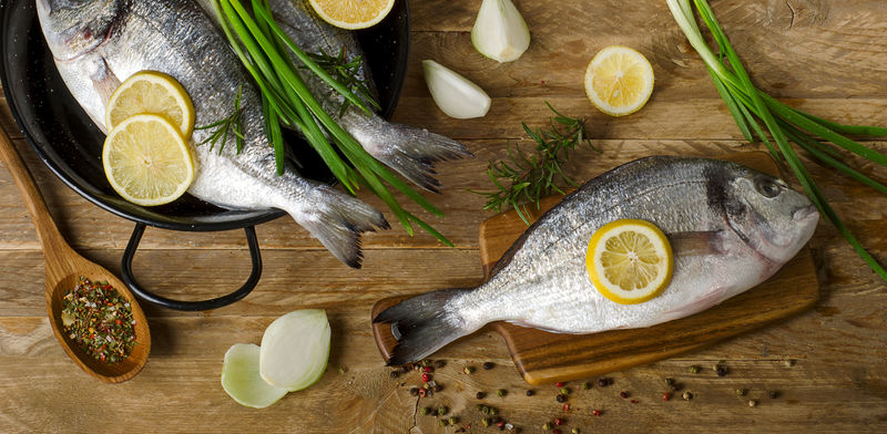 新鲜的生鱼木桌上放着香草