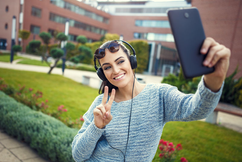 年轻大学生用平板自拍