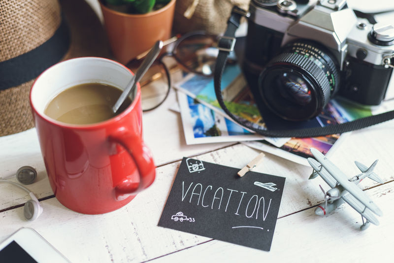 带咖啡的白色木桌上的旅行准备