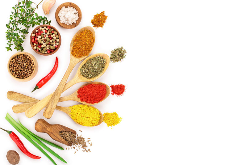 把香料放在木勺里用白色背景隔开并留出文字的复印空间俯视图平铺集合或集合