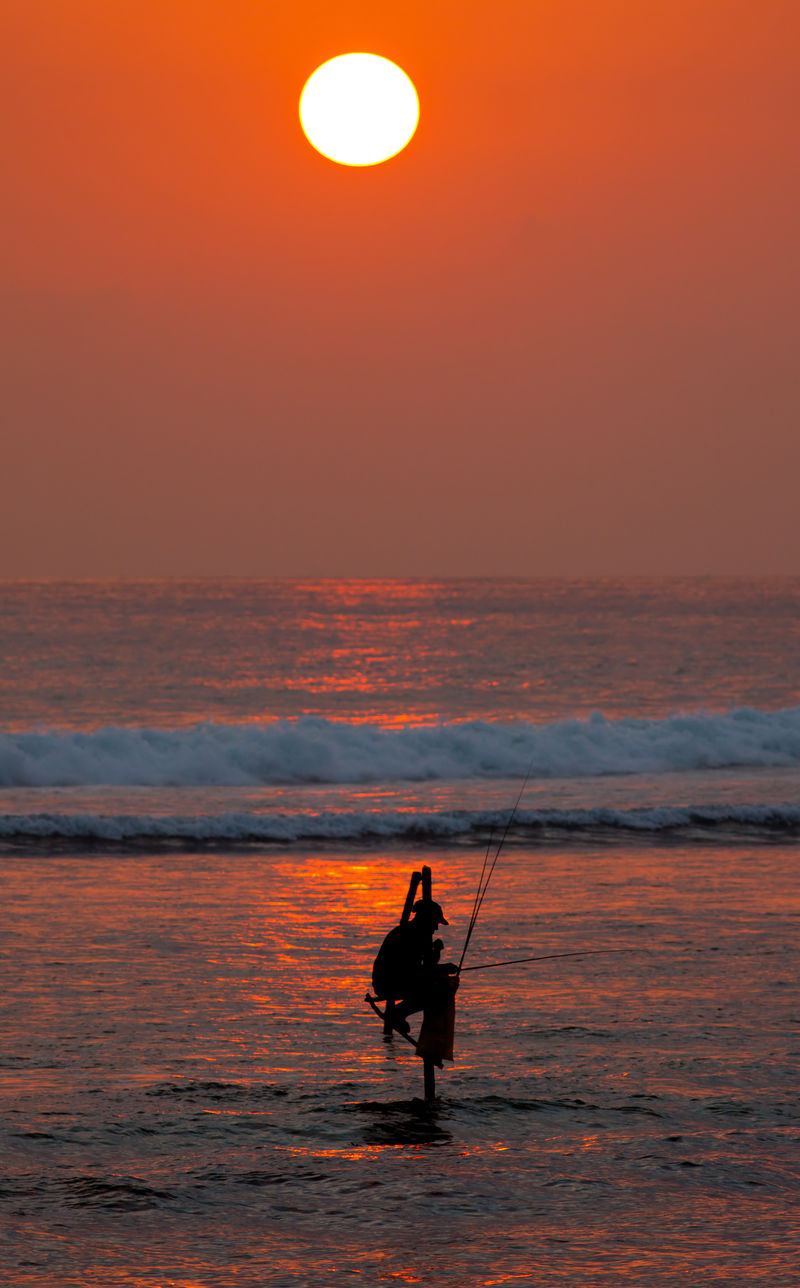 斯里兰卡加勒附近日落时分传统高跷渔民的剪影