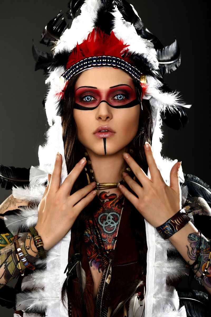 穿着美国土著服装的漂亮女人头上顶着蟑螂在画室里摆姿势