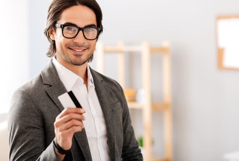 兴高采烈的商人拿着信用卡