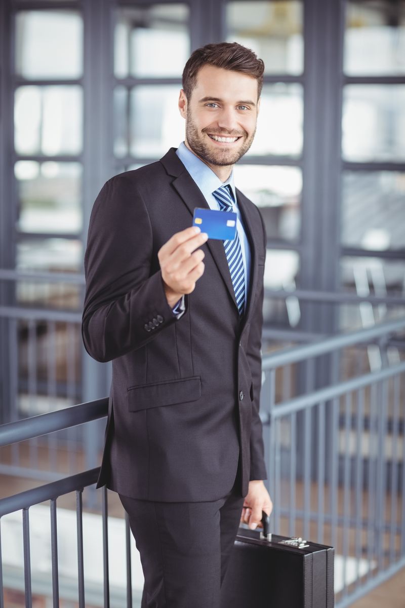 商人站在办公室时出示信用卡