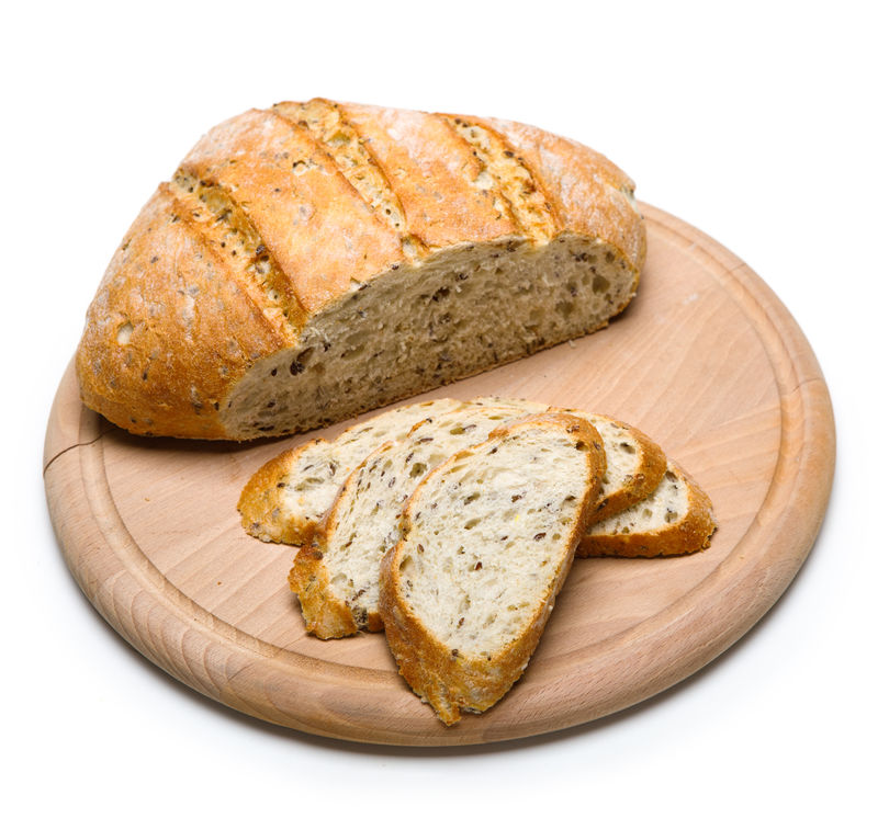 新烤的面包放在白色背景的木质砧板上