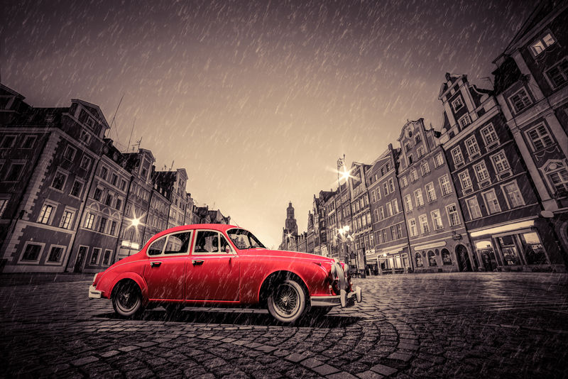 雨中鹅卵石历史古城上的复古红色汽车波兰弗罗茨瓦夫