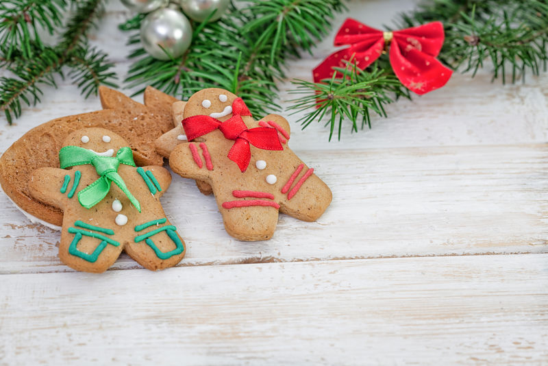 圣诞姜饼曲奇夫妇在白色木板上带复印空间