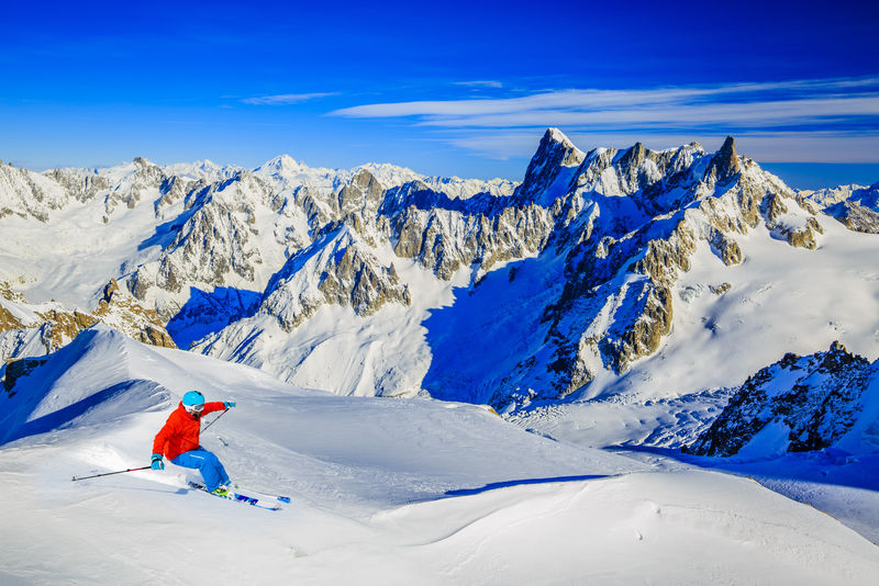 滑雪者在法国阿尔卑斯山的雪山下滑雪白朗峰雪山山脉背景是大约旦河