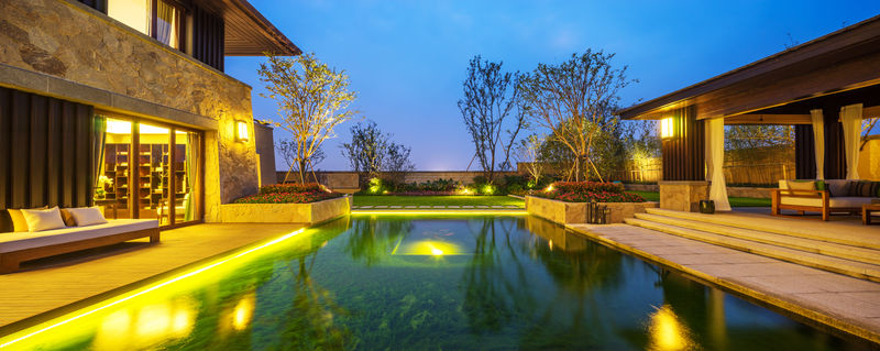 黄昏间蓝天的现代建筑之间的池塘