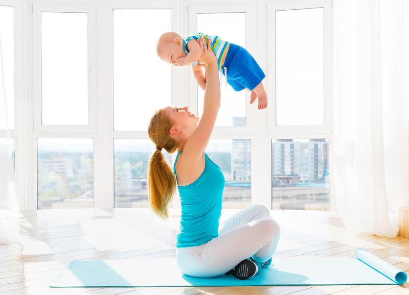 运动妈妈在家里和宝宝一起做健身和瑜伽