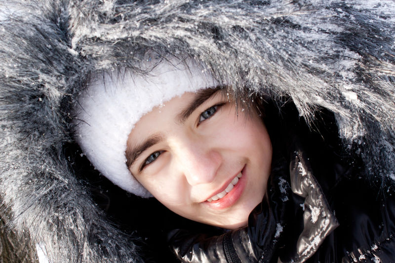 在雪地里戴着皮帽的漂亮女孩