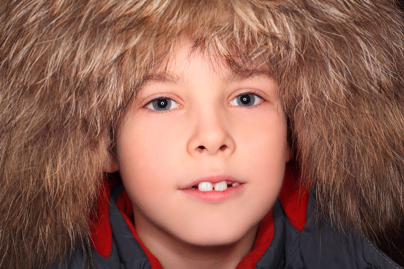 小男孩戴着皮帽看着摄像机