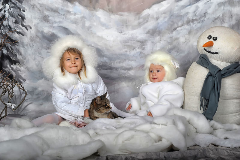 两个穿白大衣戴白皮帽的小女孩漂亮金发