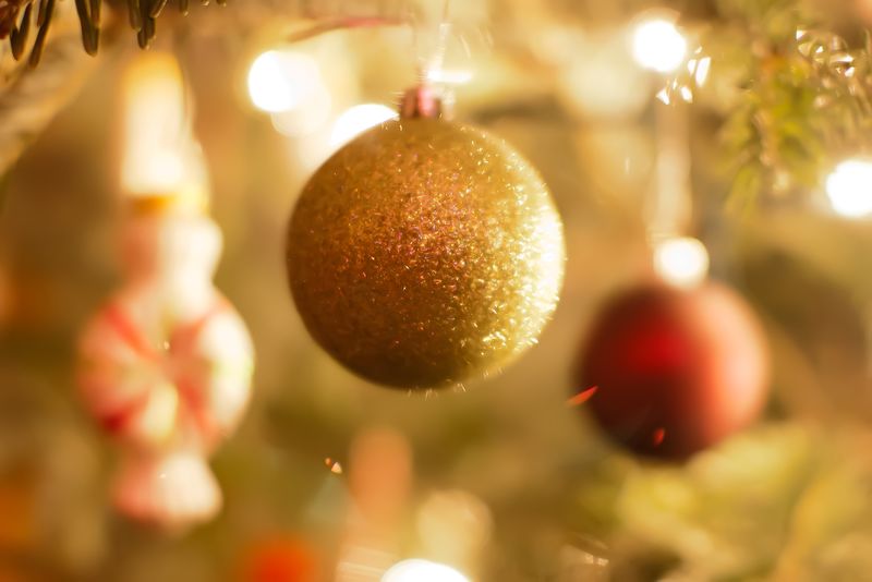 圣诞背景上有球和节日灯的冷杉树枝-带着火花