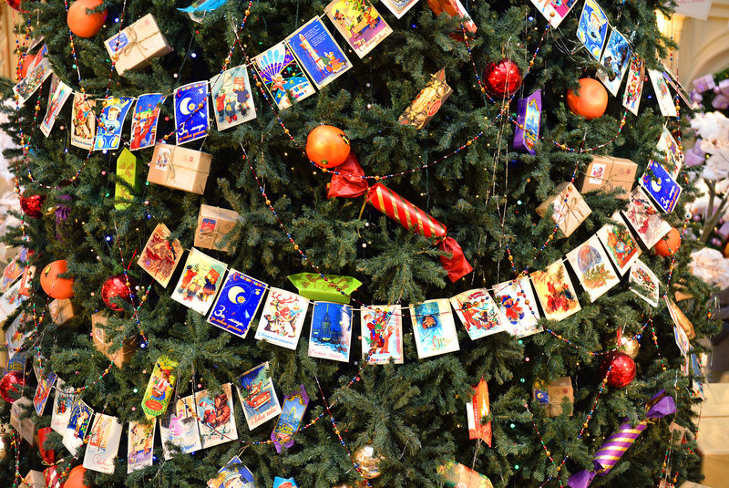 莫斯科俄罗斯-2014年11月27日：国务院商店用圣诞球糖果和旧明信片花环装饰的圣诞树